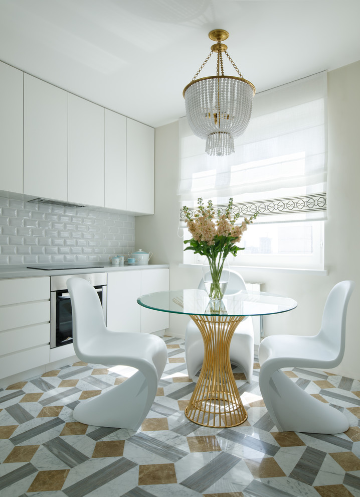 Foto på ett funkis grå linjärt kök och matrum, med släta luckor, vita skåp, vitt stänkskydd, stänkskydd i tunnelbanekakel, rostfria vitvaror och flerfärgat golv