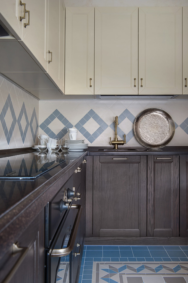 Example of a mid-sized transitional l-shaped cement tile floor and blue floor enclosed kitchen design in Moscow with recessed-panel cabinets, wood countertops, beige backsplash, cement tile backsplash, black appliances, no island, brown countertops and dark wood cabinets