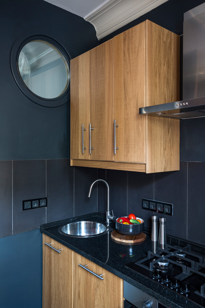 Moderne Küche mit Einbauwaschbecken, flächenbündigen Schrankfronten, hellbraunen Holzschränken und Küchenrückwand in Schwarz in Moskau