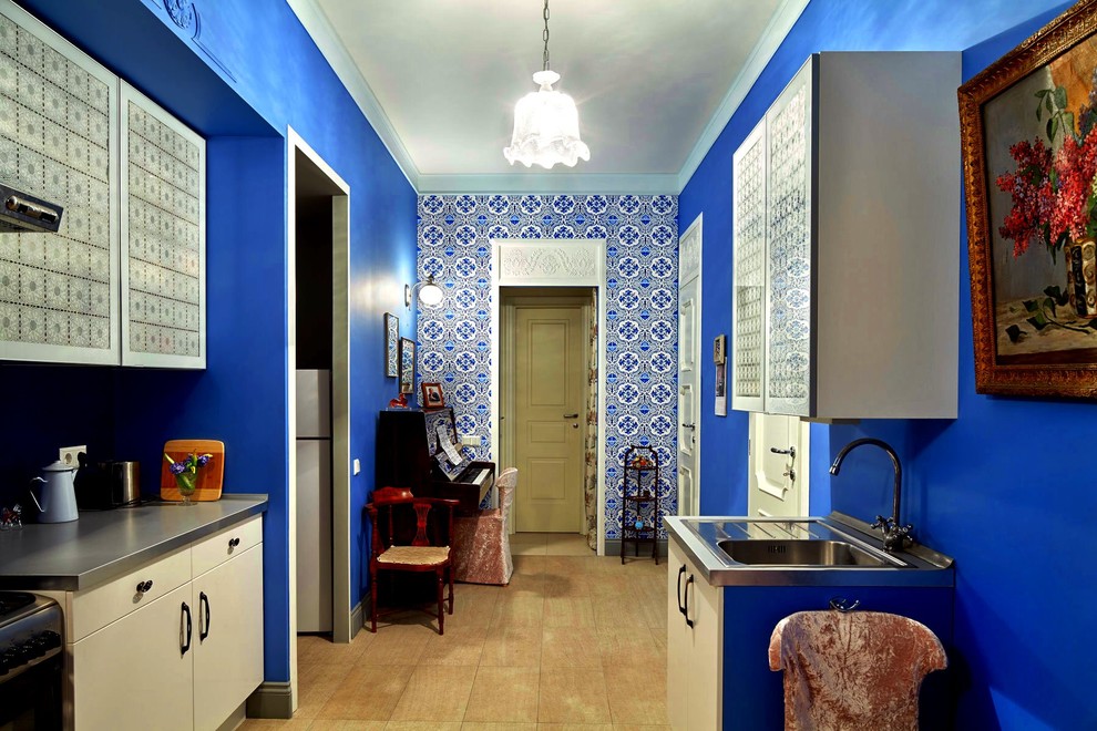 Exemple d'une cuisine tendance avec un évier 1 bac, un placard à porte plane, des portes de placard blanches et une crédence bleue.