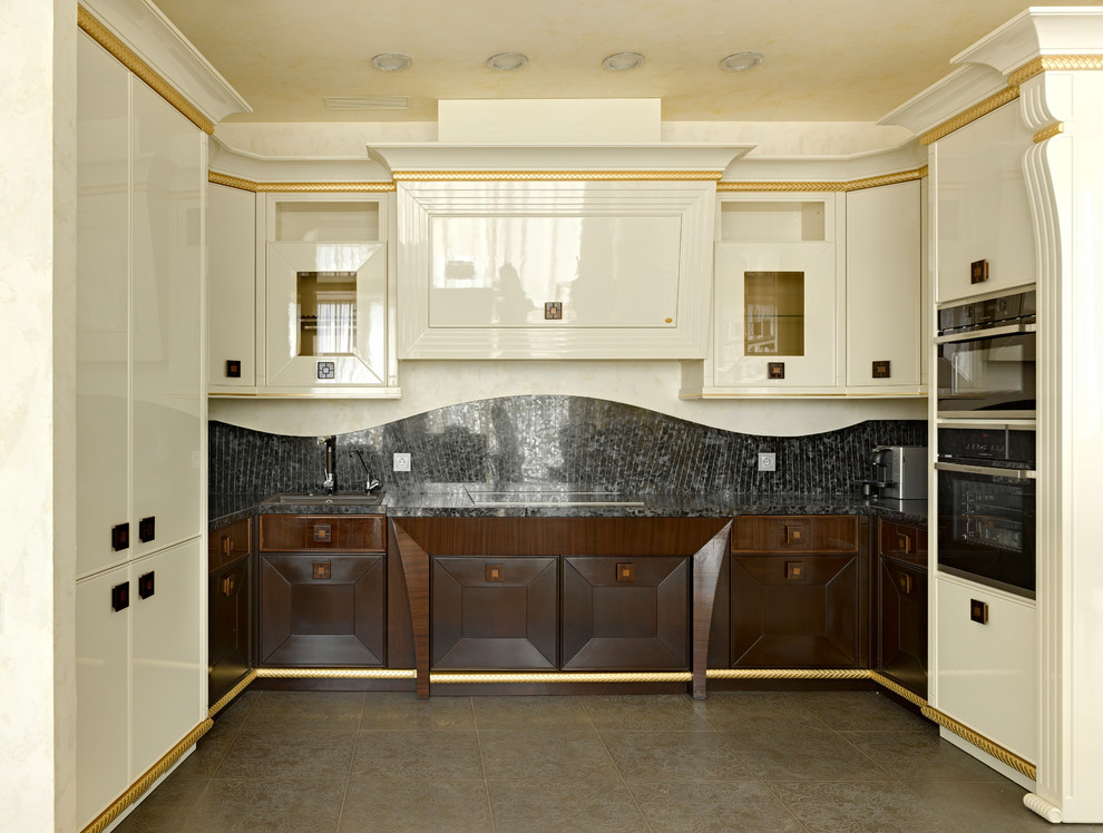 На фото: п-образная кухня-гостиная в стиле неоклассика (современная классика) с накладной мойкой, темными деревянными фасадами, черным фартуком, черной техникой, коричневым полом и черной столешницей