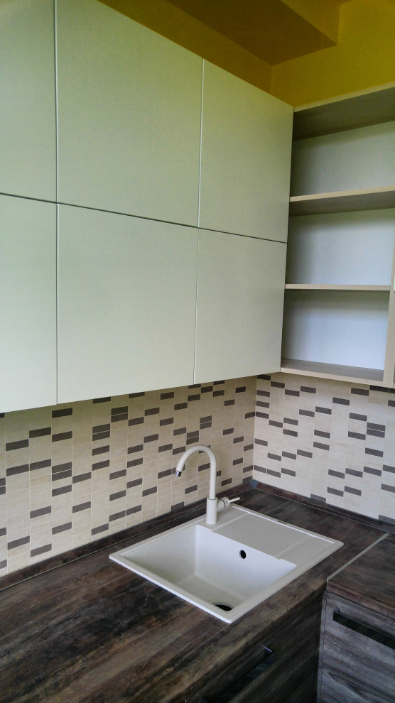 Example of a small trendy l-shaped ceramic tile and brown floor eat-in kitchen design in Moscow with a drop-in sink, flat-panel cabinets, white cabinets, wood countertops, multicolored backsplash, ceramic backsplash, white appliances and brown countertops
