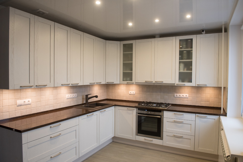 Bild på ett stort minimalistiskt kök, med en dubbel diskho, luckor med infälld panel, vita skåp, bänkskiva i kvarts, beige stänkskydd, stänkskydd i keramik, rostfria vitvaror, klinkergolv i porslin och beiget golv