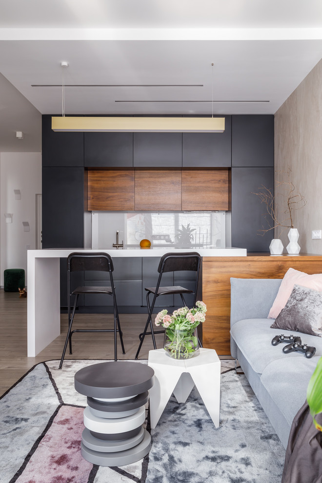 Design ideas for a contemporary single-wall open plan kitchen in Moscow with flat-panel cabinets, black cabinets, white splashback, a breakfast bar, beige floors and white worktops.