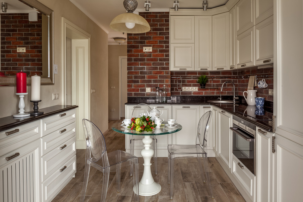 Design ideas for a classic l-shaped enclosed kitchen in Moscow with a built-in sink, recessed-panel cabinets, white cabinets, brown splashback, stainless steel appliances, no island and brown floors.