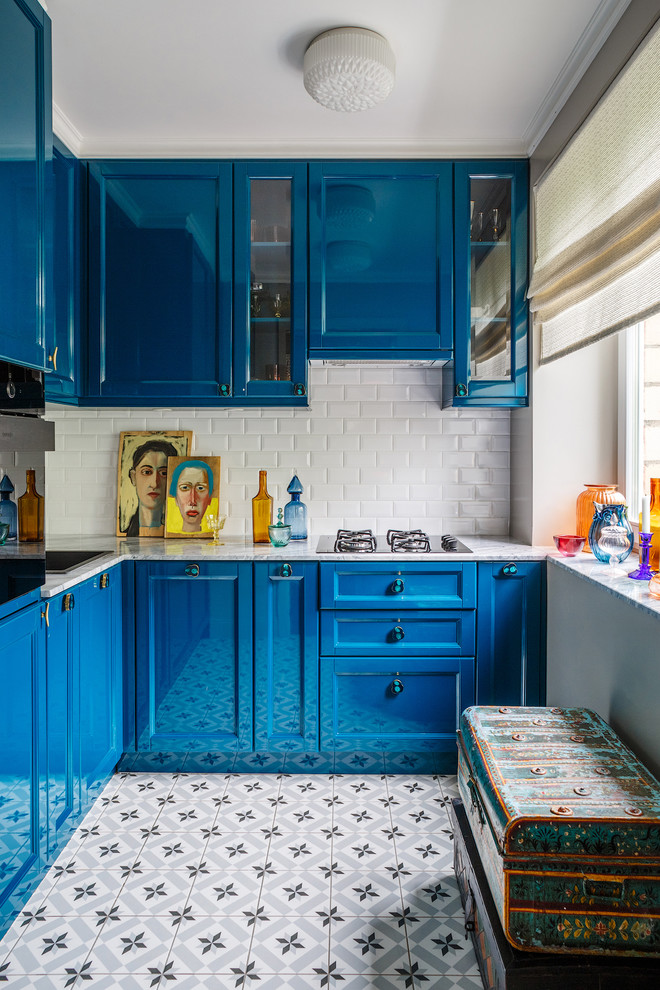 Modelo de cocinas en L contemporánea cerrada sin isla con fregadero encastrado, armarios estilo shaker, puertas de armario azules, salpicadero blanco, salpicadero de azulejos tipo metro y electrodomésticos negros