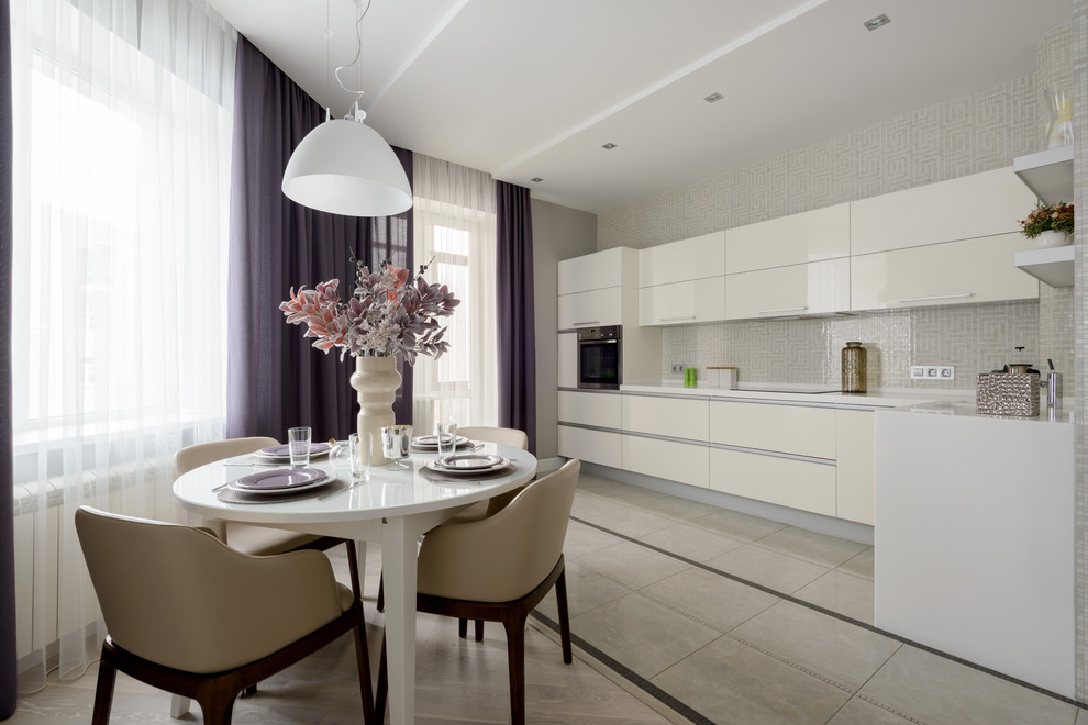 Exempel på ett modernt kök, med släta luckor, vita skåp, grått stänkskydd, stänkskydd i mosaik, rostfria vitvaror och beiget golv