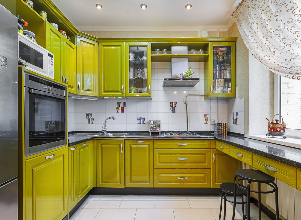 Photo of a contemporary u-shaped kitchen in Moscow with a built-in sink, raised-panel cabinets, yellow cabinets, white splashback, stainless steel appliances and no island.