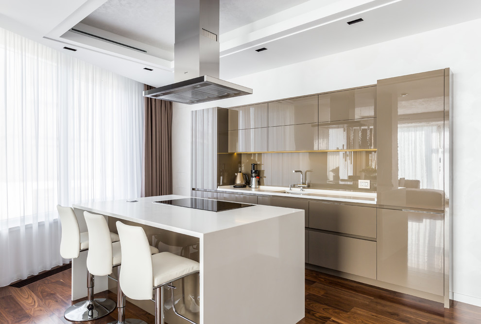 Inspiration for a medium sized contemporary l-shaped kitchen/diner in Saint Petersburg with composite countertops, dark hardwood flooring, an island, brown floors, a single-bowl sink, flat-panel cabinets, glass sheet splashback, black appliances, beige cabinets and beige splashback.