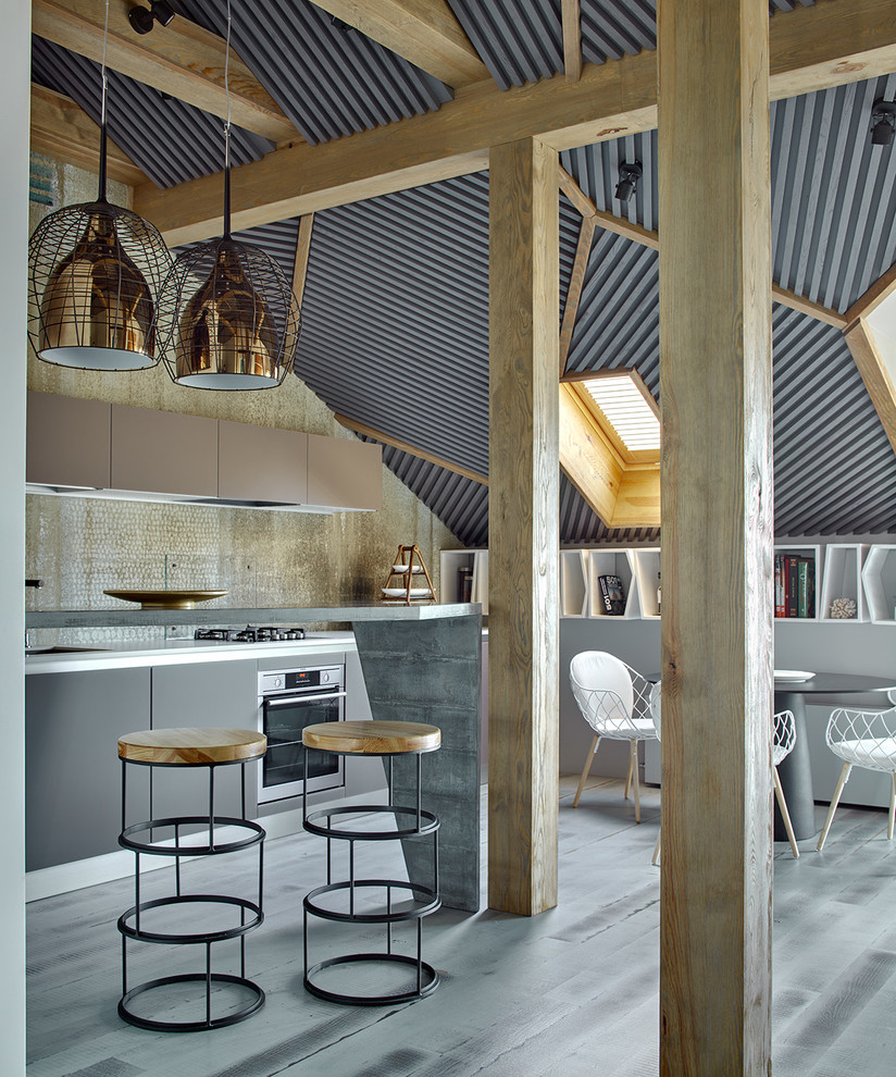Стильный дизайн: кухня-гостиная в современном стиле с плоскими фасадами, серыми фасадами, серым фартуком, техникой из нержавеющей стали и полуостровом - последний тренд