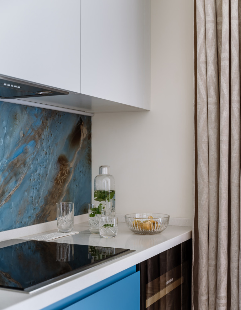 Diseño de cocina contemporánea con armarios con paneles lisos, puertas de armario azules, salpicadero multicolor y suelo marrón