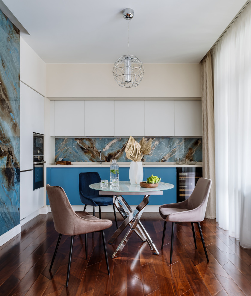Diseño de cocina contemporánea con armarios con paneles lisos, puertas de armario azules, salpicadero multicolor y suelo marrón
