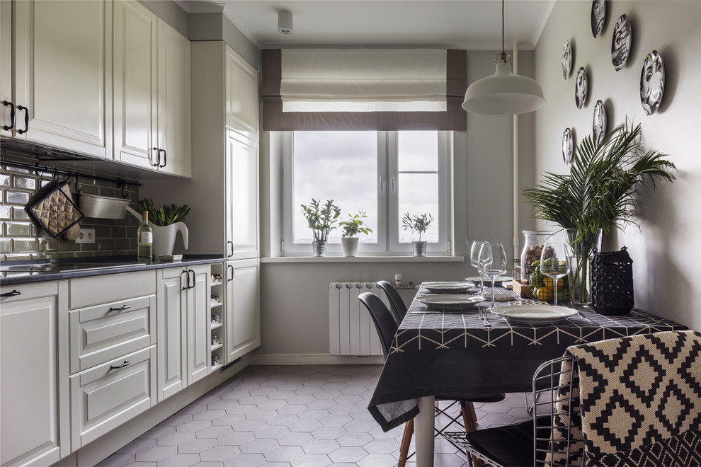 Photo of a traditional enclosed kitchen in Moscow with raised-panel cabinets, white cabinets, grey floors, metro tiled splashback and no island.