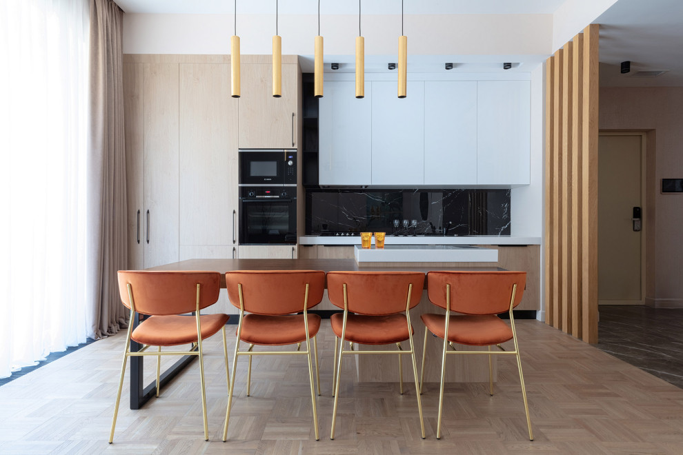 Foto di una cucina contemporanea di medie dimensioni con ante lisce, ante beige, paraspruzzi nero, paraspruzzi con piastrelle di vetro, elettrodomestici da incasso, pavimento beige e top bianco