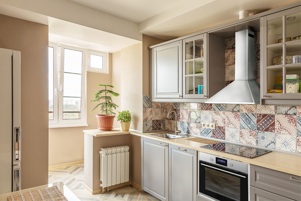This is an example of a small contemporary single-wall kitchen/diner in Saint Petersburg with a single-bowl sink, raised-panel cabinets, grey cabinets, wood worktops, multi-coloured splashback, ceramic splashback, stainless steel appliances, porcelain flooring, no island, beige floors and beige worktops.