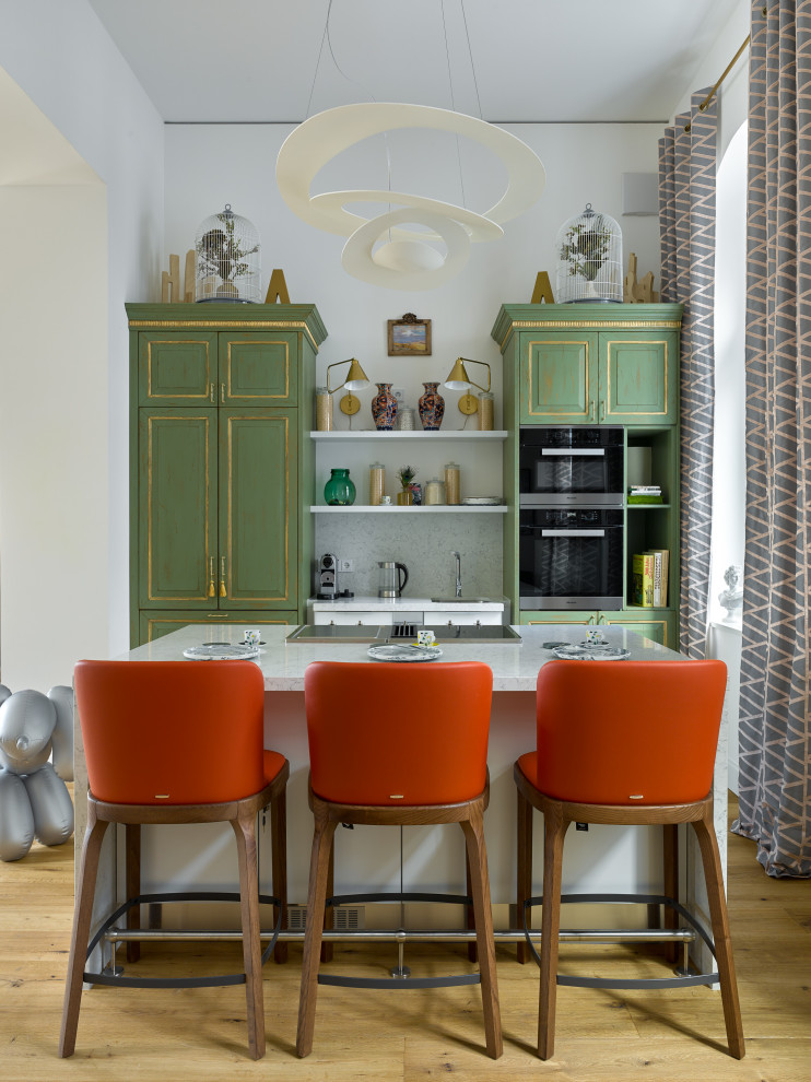 Imagen de cocina lineal contemporánea con puertas de armario verdes, una isla, suelo marrón y encimeras blancas