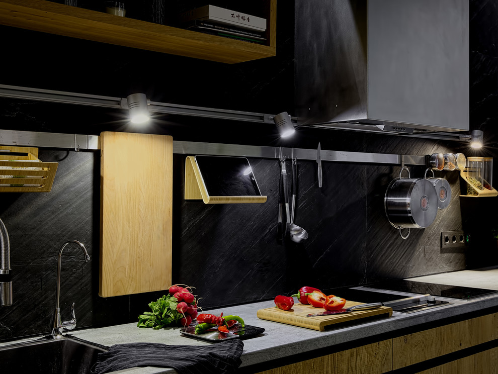 Contemporary kitchen in Moscow with flat-panel cabinets, medium wood cabinets, black splashback and stone slab splashback.