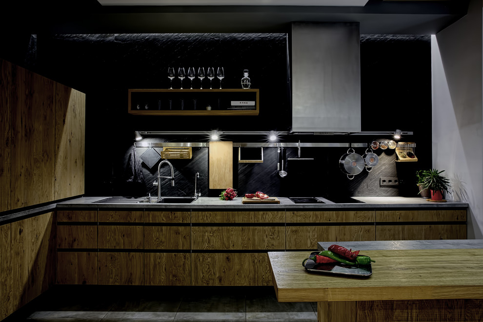 Свежая идея для дизайна: угловая кухня-гостиная в современном стиле с двойной мойкой, плоскими фасадами, фасадами цвета дерева среднего тона, черным фартуком, техникой из нержавеющей стали, полом из керамической плитки и полуостровом - отличное фото интерьера