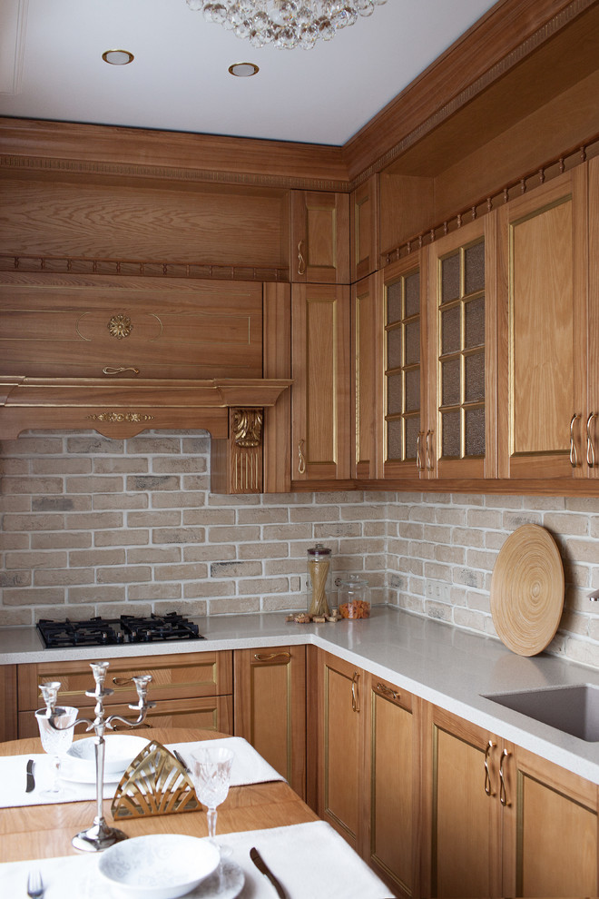 Inredning av ett klassiskt avskilt, litet vit vitt l-kök, med luckor med infälld panel, bänkskiva i koppar, beige stänkskydd, stänkskydd i tegel, en undermonterad diskho och skåp i ljust trä