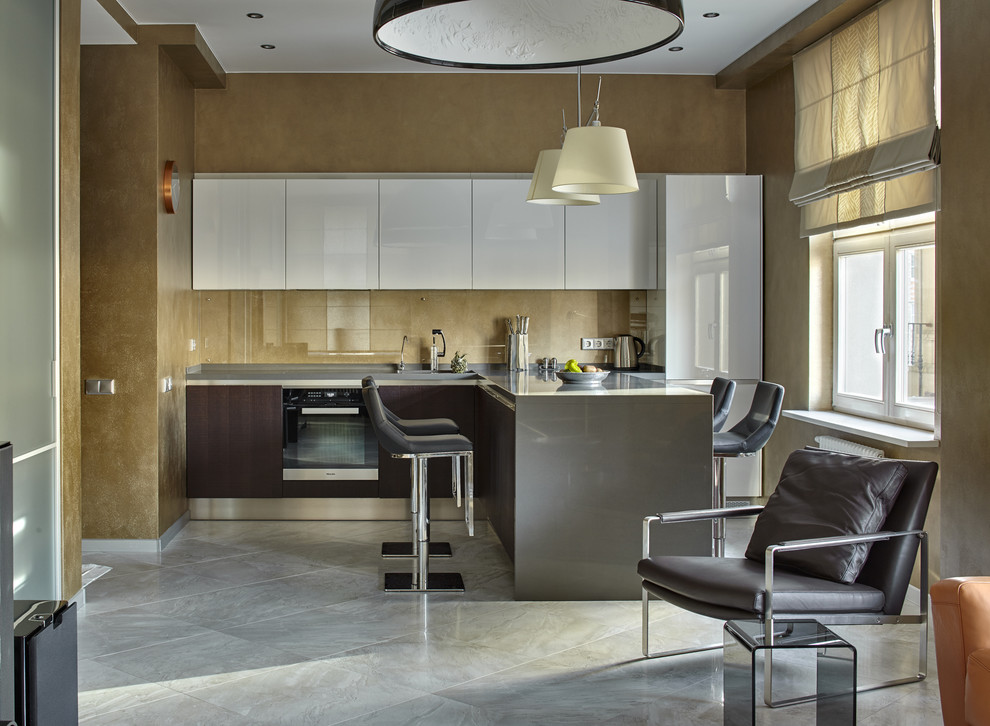Idée de décoration pour une cuisine ouverte design en L avec un placard à porte plane, une crédence beige, une crédence en feuille de verre, un électroménager en acier inoxydable, un sol en marbre, une péninsule et un sol gris.
