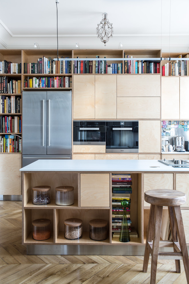Esempio di una cucina chic con ante lisce, ante beige, elettrodomestici in acciaio inossidabile, pavimento in legno massello medio, pavimento beige e top bianco