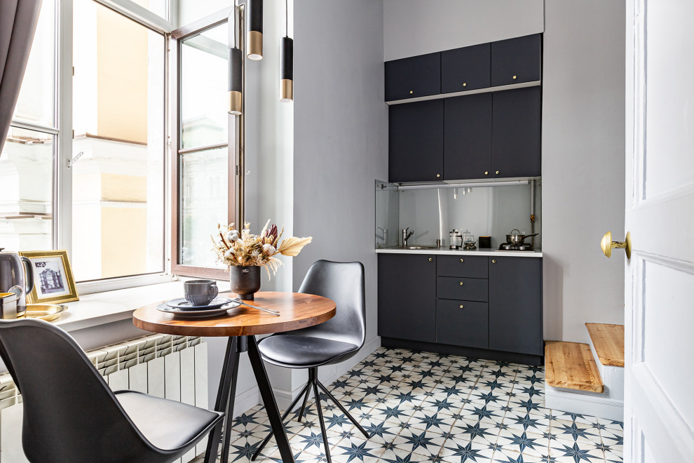 Example of a small 1950s porcelain tile and blue floor eat-in kitchen design in Saint Petersburg with a drop-in sink, flat-panel cabinets, blue cabinets, white backsplash, glass sheet backsplash and white countertops