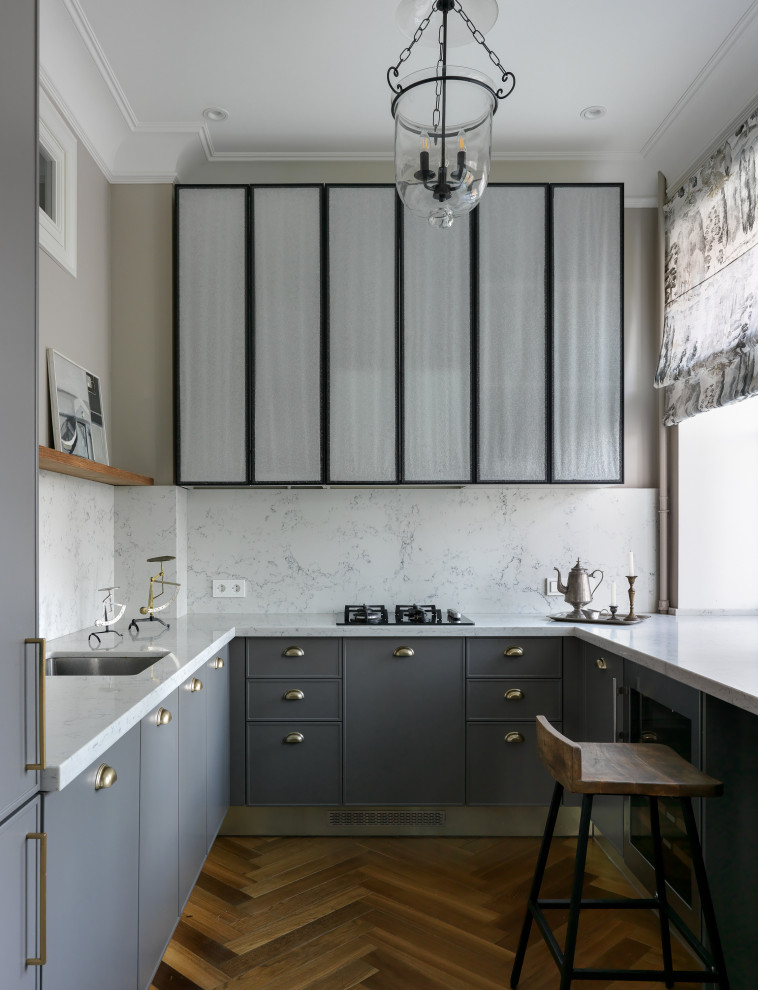Klassisk inredning av ett avskilt, litet vit vitt u-kök, med en undermonterad diskho, luckor med profilerade fronter, grå skåp, vitt stänkskydd och brunt golv