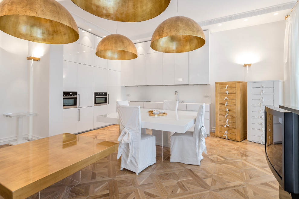 Photo of a contemporary l-shaped open plan kitchen in Moscow with flat-panel cabinets, white cabinets, white splashback, black appliances, medium hardwood flooring and no island.