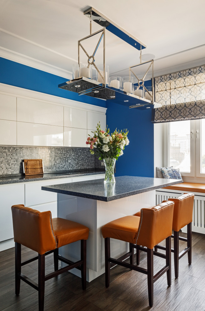 Foto di un cucina con isola centrale minimal con ante lisce, ante bianche, paraspruzzi grigio, parquet scuro, pavimento marrone e top grigio