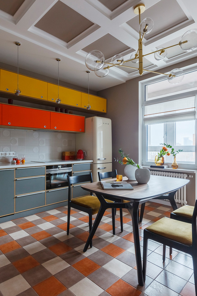 Стильный дизайн: прямая кухня в стиле ретро с серым фартуком, разноцветным полом, обеденным столом, плоскими фасадами, серыми фасадами, цветной техникой, серой столешницей и двухцветным гарнитуром - последний тренд