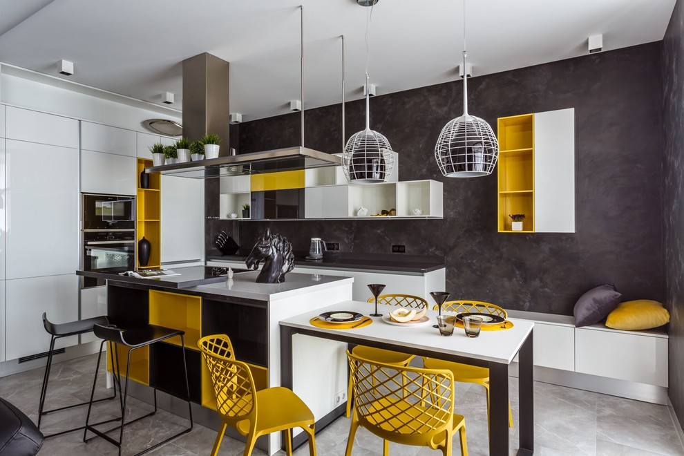 На фото: прямая кухня-гостиная в современном стиле с плоскими фасадами, белыми фасадами, серым фартуком, черной техникой, серым полом и островом с