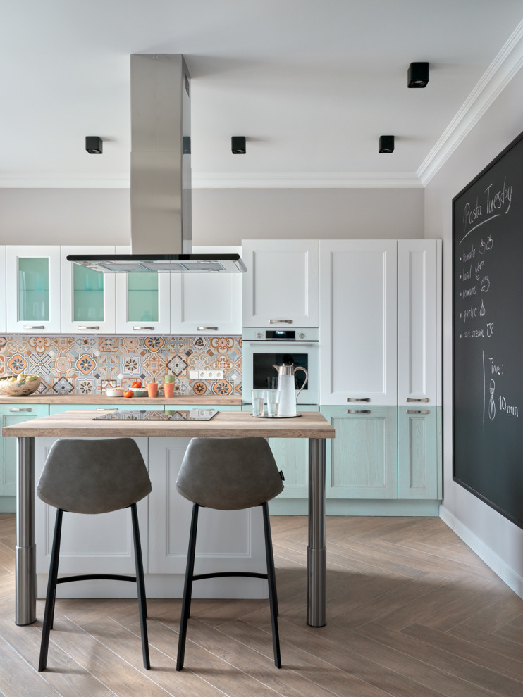 Example of a mid-sized transitional galley beige floor open concept kitchen design in Moscow with white cabinets, multicolored backsplash, an island, recessed-panel cabinets, wood countertops and beige countertops