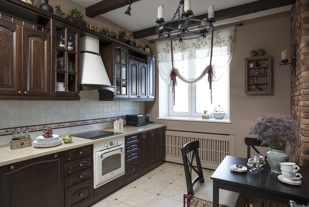 На фото: кухня в классическом стиле с темными деревянными фасадами с