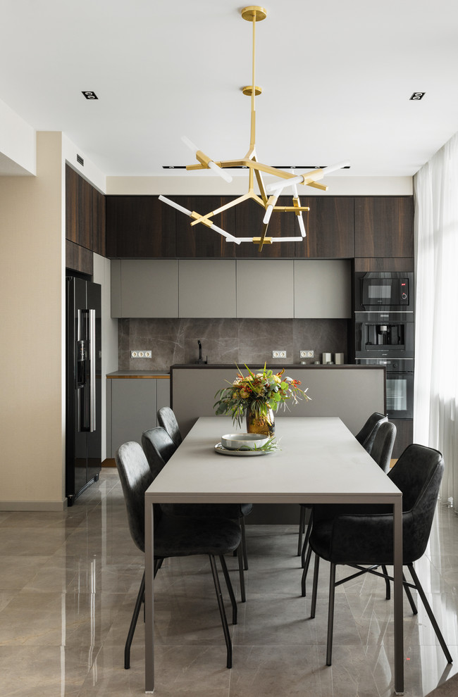 Mid-sized trendy l-shaped porcelain tile and gray floor eat-in kitchen photo in Saint Petersburg with flat-panel cabinets, gray cabinets, gray backsplash, porcelain backsplash, black appliances, gray countertops, a drop-in sink and an island