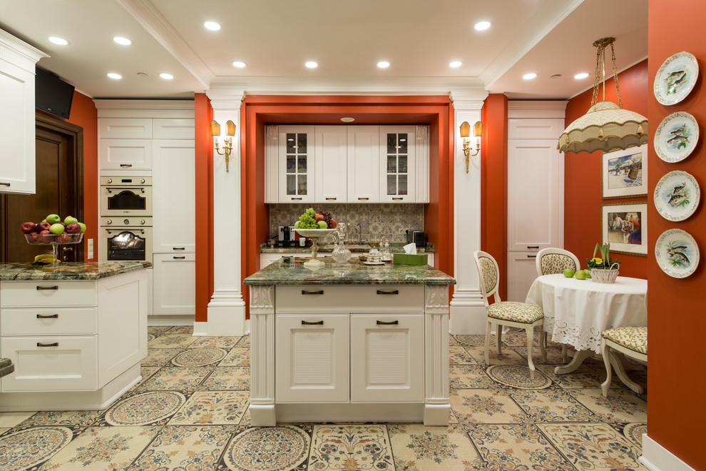 Klassisk inredning av ett kök och matrum, med skåp i shakerstil, vita skåp och flera köksöar