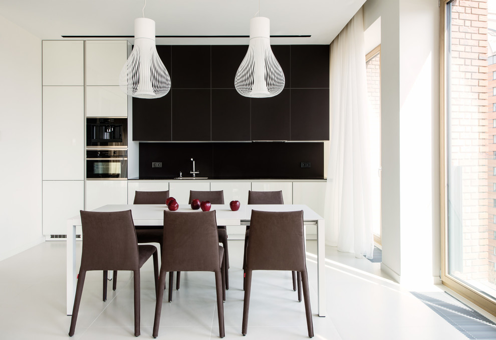 Immagine di una cucina design con ante lisce, ante bianche, paraspruzzi nero, elettrodomestici neri, nessuna isola, pavimento bianco e top nero