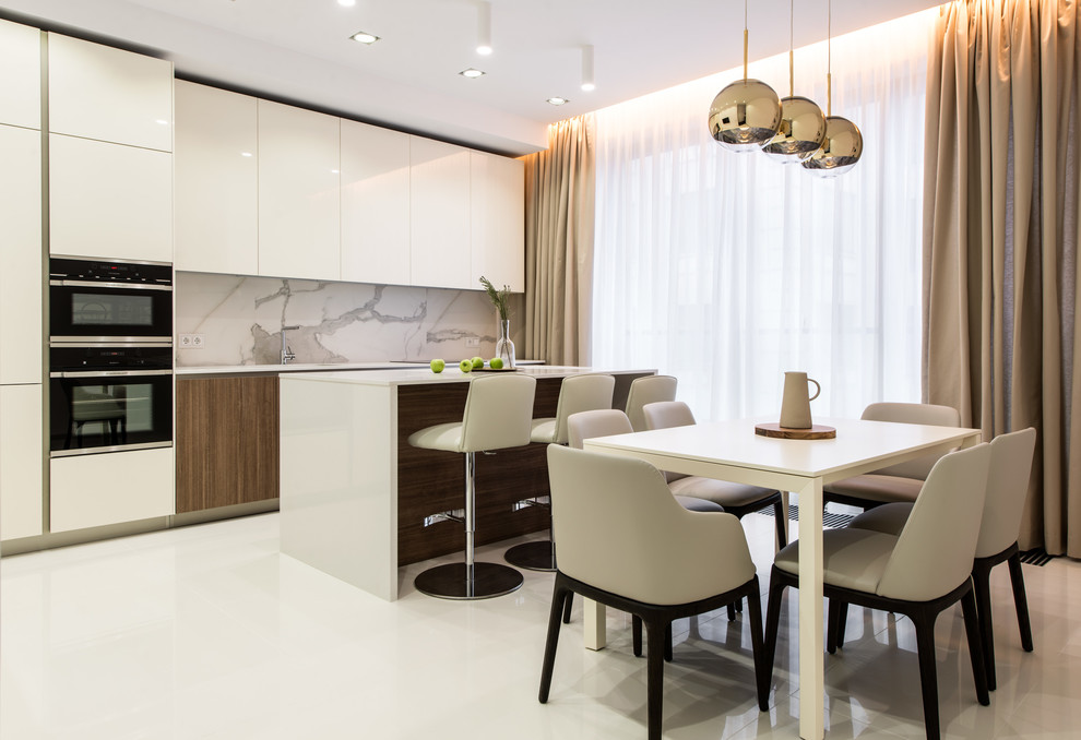 Immagine di una cucina design con ante lisce, ante bianche, paraspruzzi grigio, elettrodomestici neri, pavimento bianco e top bianco