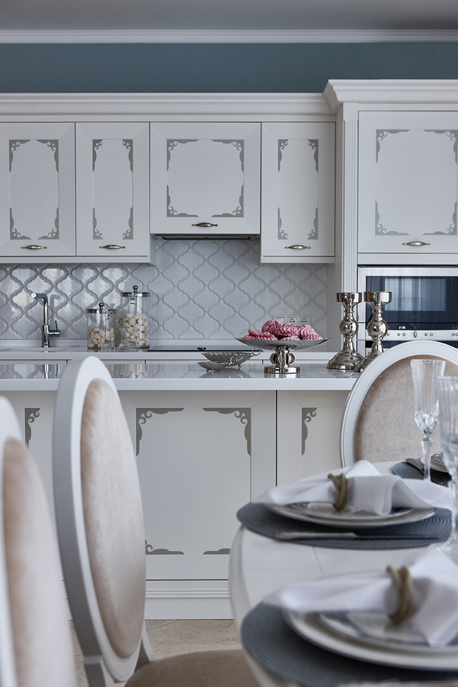 Foto di una cucina classica di medie dimensioni con lavello integrato, ante bianche, top in superficie solida, paraspruzzi bianco, elettrodomestici in acciaio inossidabile e pavimento in gres porcellanato