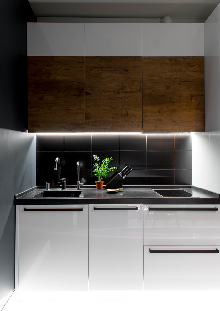 Exempel på ett mellanstort modernt svart linjärt svart kök och matrum, med släta luckor, vita skåp, svart stänkskydd, en integrerad diskho, bänkskiva i koppar, stänkskydd i keramik, vita vitvaror, klinkergolv i keramik och flerfärgat golv