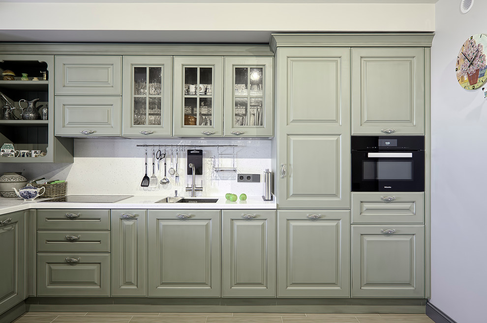 Идея дизайна: отдельная, угловая кухня в современном стиле с двойной мойкой, фасадами с выступающей филенкой, белым фартуком и черной техникой