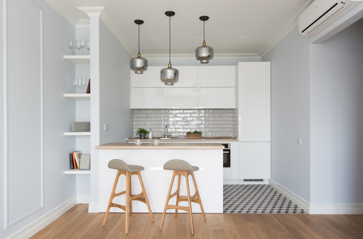 Scandi single-wall open plan kitchen in Moscow with a built-in sink, flat-panel cabinets, white cabinets, white splashback, stainless steel appliances, a breakfast bar and multi-coloured floors.