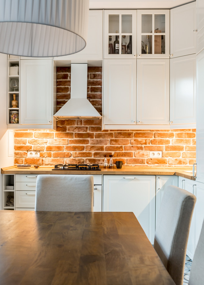 Photo of a small contemporary l-shaped open plan kitchen in Moscow with white cabinets, brown splashback, brick splashback and no island.