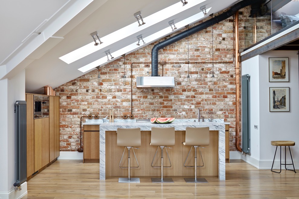 Immagine di un cucina con isola centrale industriale con ante lisce, paraspruzzi marrone, pavimento in legno massello medio e ante in legno chiaro