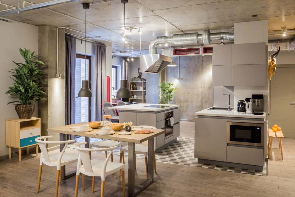 Esempio di una cucina industriale con pavimento in legno massello medio, pavimento marrone, lavello da incasso, ante lisce, ante grigie e elettrodomestici in acciaio inossidabile