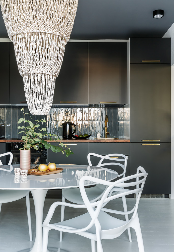 Foto di una cucina contemporanea con ante lisce, ante nere, paraspruzzi grigio, elettrodomestici neri, nessuna isola, pavimento bianco e top marrone