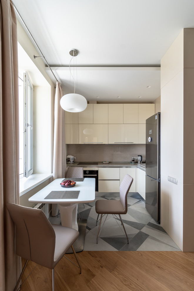 Moderne Wohnküche in U-Form mit flächenbündigen Schrankfronten, beigen Schränken, Küchenrückwand in Grau, Küchengeräten aus Edelstahl, grauem Boden und grauer Arbeitsplatte in Moskau