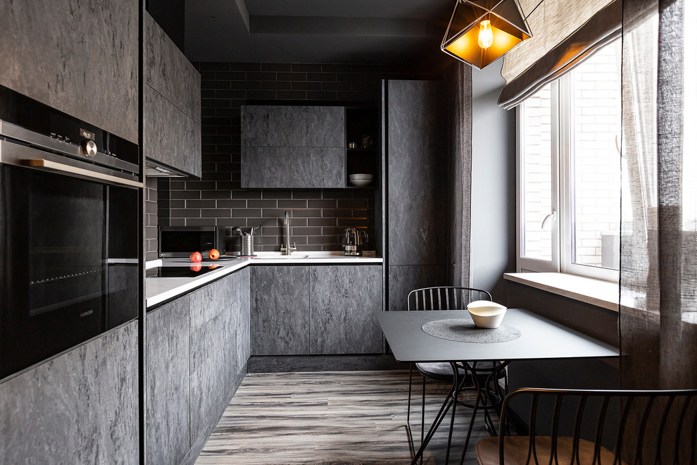 Example of a trendy l-shaped medium tone wood floor and brown floor eat-in kitchen design in Saint Petersburg with an integrated sink, flat-panel cabinets, gray cabinets, gray backsplash, stainless steel appliances and white countertops