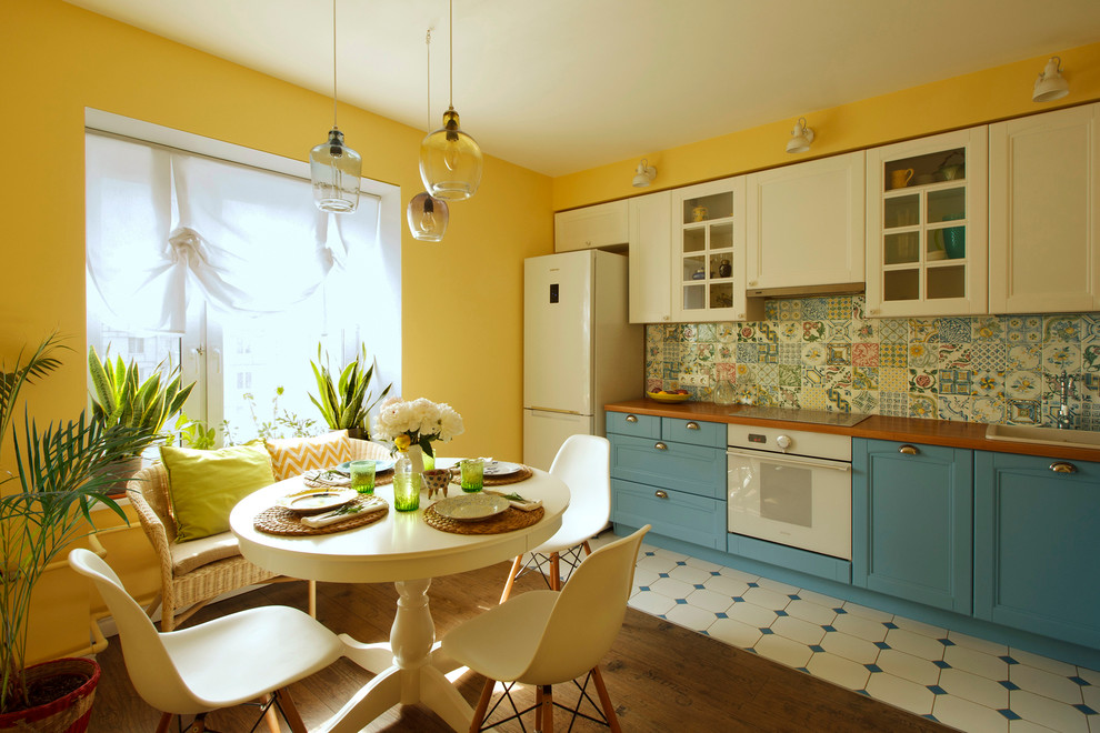 Eat-in kitchen - mid-sized traditional l-shaped eat-in kitchen idea in Moscow with recessed-panel cabinets, white cabinets, multicolored backsplash, porcelain backsplash, no island, a drop-in sink and white appliances