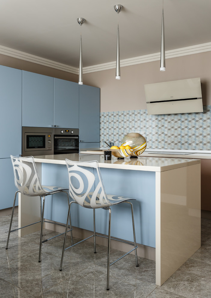 Mittelgroße Moderne Küche mit flächenbündigen Schrankfronten, blauen Schränken, Küchengeräten aus Edelstahl, Kücheninsel, grauem Boden und bunter Rückwand in Sonstige