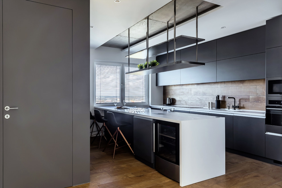 Стильный дизайн: прямая кухня в современном стиле с плоскими фасадами, черными фасадами, коричневым фартуком, островом, коричневым полом и белой столешницей - последний тренд